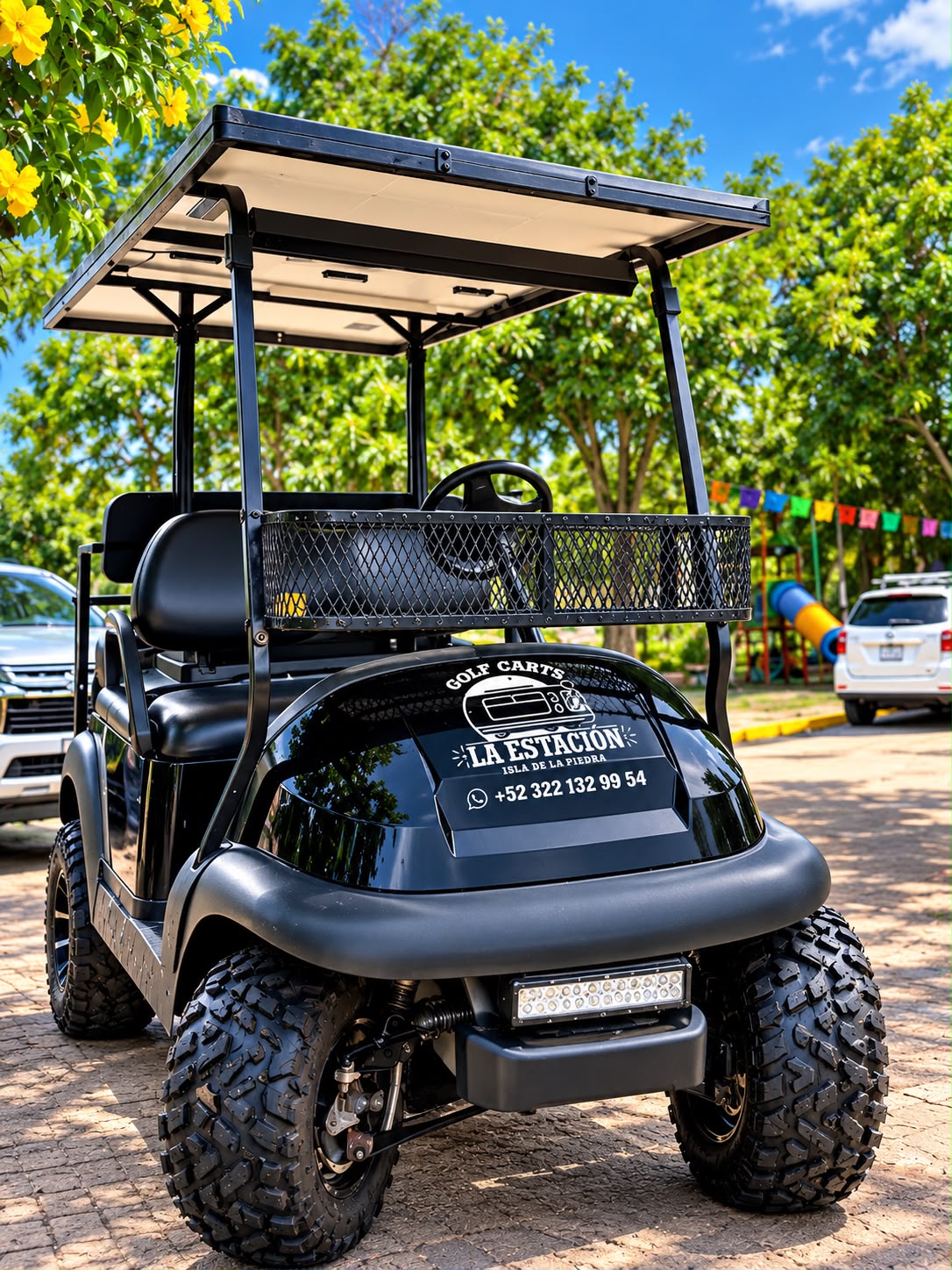 Carrito de golf negro de La Estación frente al acceso a la playa de San Pancho